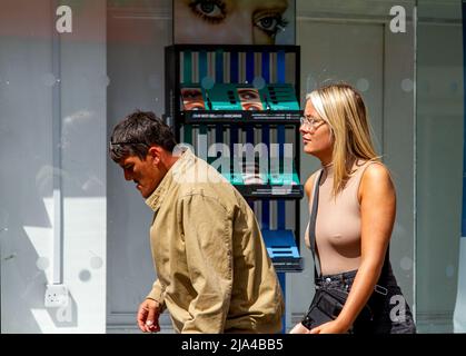 Dundee, Tayside, Schottland, Großbritannien. 27.. Mai 2022. Wetter in Großbritannien. Die Temperaturen in Teilen von Nordostschottland erreichten aufgrund der stürmischen Bedingungen und der warmen Sonne 17 Grad. Trotz der starken Winde und der sonnigen Zeiten am Tag sind nur einige modische Dundee-Frauen im Stadtzentrum unterwegs, verbringen den Tag mit Shopping und Geselligkeit, während sie das warme Spätfrühlingswetter genießen. Leider geht eine glamouröse junge Frau mit langen blonden Haaren an einem der`s drogenbedingten Probleme von Dundee vorbei. Kredit: Dundee Photographics/Alamy Live Nachrichten Stockfoto